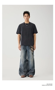 Detail of dark wash wide-leg denim jeans with unique plaid pocket accent and stacked hem