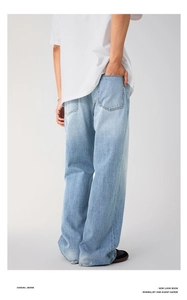 Detail shot of men's loose fit soda blue washed denim jeans with back pocket design