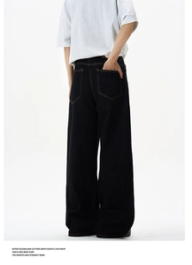 Macro detail of black wide-leg denim jeans featuring classic contrast yellow stitching