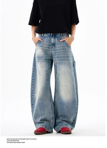 Close-up of baggy light blue washed jeans featuring vintage carpenter hammer loop details