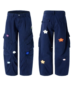 Détail du pantalon cargo bleu marine avec broderie florale 3D colorée et poches latérales