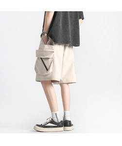 Detail of cargo shorts side pocket with black diagonal zipper on beige quick-dry fabric