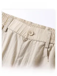 Detailansicht der khakifarbenen Lyocell-Hose mit Knopfverschluss und elastischem Hosenbund