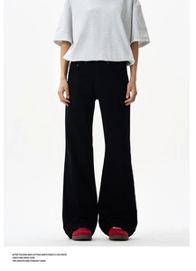 Detail showing high-waisted black wide leg trousers with premium stitching and elegant drape