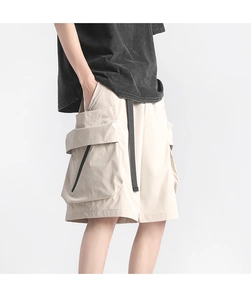 Detail shot of cargo shorts featuring large functional pockets and black decorative zipper