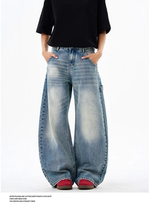 Detail view of light blue baggy jeans with vintage wash and professional stitching quality