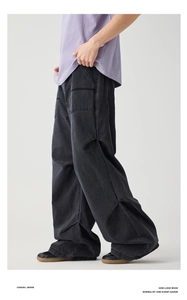Detail of dark gray vintage wash denim cargo pants with large side pockets and relaxed fit