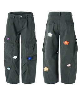 Détail du pantalon cargo gris foncé avec fleurs tricotées en 3D et poches latérales