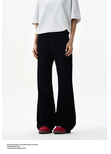 Detail of high-waist black wide-leg vibe pants with rivets and a slim flared silhouette