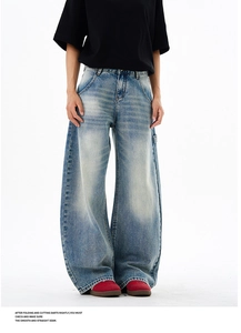 Macro detail of vintage wash blue wide-leg jeans featuring whiskers and 3D seam construction