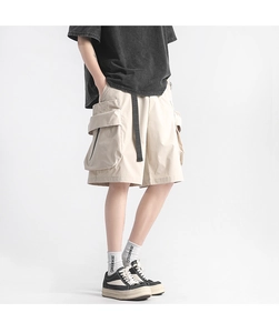 Detail view of khaki utility shorts featuring large 3D pockets and black hanging belt