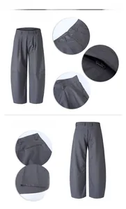 Detail view of dark grey curved cut trousers showing waistband zipper and pocket stitching