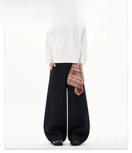 Détail d'un jean baggy noir avec bandana à carreaux rouge et coupe à jambes larges
