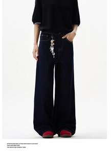 Detail of dark blue wide-leg denim jeans featuring high-waisted cut and metal key ring accessory
