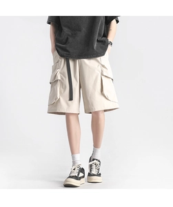 Detail of cargo shorts with large pockets and long black decorative belt in street style