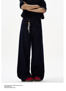 Close-up of deep blue denim jeans featuring contrast stitching and a decorative keychain