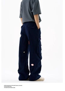 Détails du pantalon cargo bleu marine avec broderies florales colorées et grandes poches