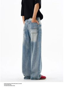 Detail view of American style loose wide leg jeans with vintage light wash blue finish