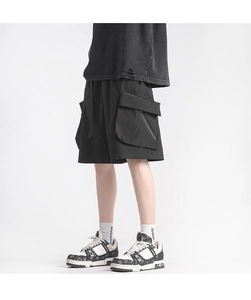 Detail showing loose-fit black cargo shorts with large pockets and street style texture