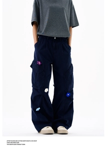 Détails macro des appliques florales en crochet 3D sur un pantalon cargo bleu marine chic