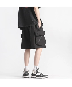 Detail shot of the large 3D cargo pocket and zipper on black techwear shorts