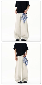 Detail of cream-colored wide-leg trousers with a blue and white checkered bandana accessory