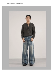 Detail of grey Henley long sleeve shirt and washed blue wide-leg jeans with vintage look