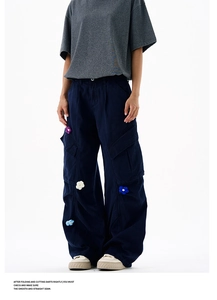 Détails des patchs floraux 3D colorés et broderies sur ce pantalon cargo bleu foncé