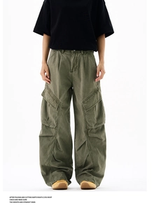 Detail of army green wide-leg cargo pants with distressed wash and pleated knee texture