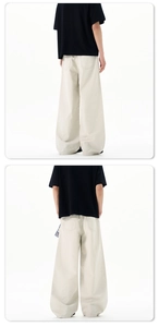 Rear view of beige oversized wide-leg trousers with symmetrical back pockets in a minimalist style