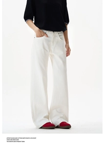 Detail view of white high-waist flared pants with rivet accents and wide leg design