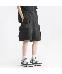 Detail showing tactical cargo shorts with large flap pockets and decorative long webbing