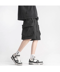 Detail view of large cargo flap pockets on black loose fit quick-dry streetwear shorts