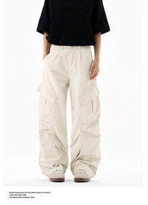 Detail view of beige cargo pants with large flap pockets and clean stitching finish