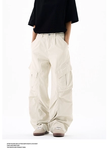 Detail view of cream cargo pants featuring large 3D pockets and pleated knee design