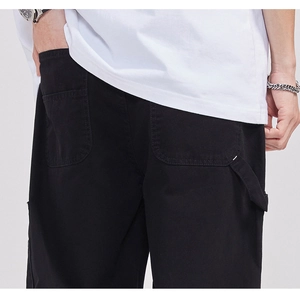 Detail of men's black cargo pants featuring back pockets and a utility hammer loop