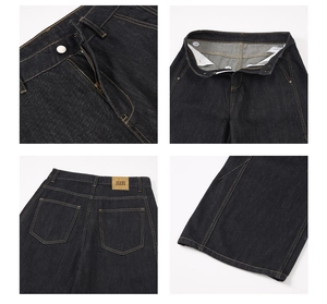 Macro view of dark wash denim jeans showing zipper fly and brown leather back label