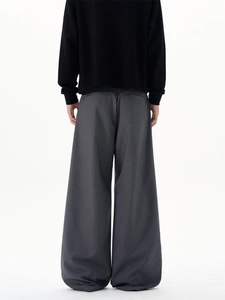 Deep grey wide-leg trousers with curved drape, shown from behind on a minimalist background