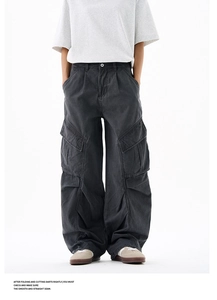 Detailed close-up of washed grey cargo pants with oversized 3D pockets and high-street style