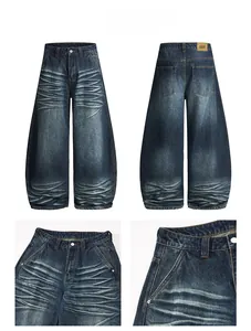 Detail of dark blue wide-leg jeans with vintage wash, whiskered texture and leather patch