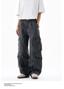 Detailed view of dark grey wide-leg cargo pants with 3D pleated pockets and washed finish