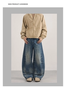 Close-up of baggy dark blue washed jeans with cat-whisker detailing and oversized fit
