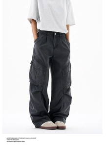 Detail of dark gray cargo pants showing side pockets and 3D pleated knee construction
