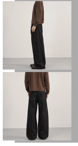 Detail view of heavy denim wide-leg jeans in dark charcoal with retro paneling design