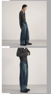Detail of baggy dark blue denim jeans featuring vintage washed whiskers and wide-leg cut