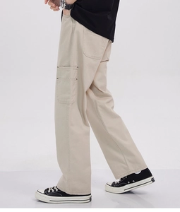 Detail view of khaki cargo pants featuring large side pockets and twill cotton fabric