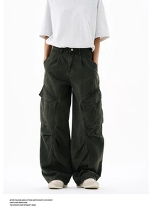 Detail of dark green cargo pants featuring large side pockets and vintage washed fabric