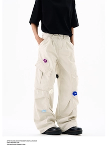 Détail d'un pantalon cargo avec broderies florales 3D et poches latérales pratiques