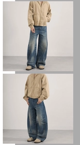 Close-up of vintage washed blue wide-leg jeans and khaki zip jacket in a minimal setting