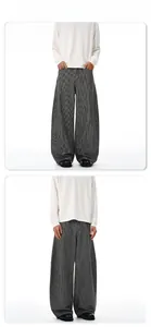 Détail du pantalon large à rayures et du t-shirt blanc à manches longues style cleanfit